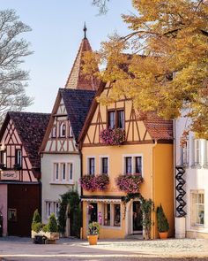 an old european style house with flowers on the windows