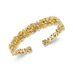 This stunning bracelet is adorned with an array of orangy-yellow diamonds in various shapes, meticulously set in a flexible design that molds effortlessly to the wrist. Each diamond, carefully selected for its exceptional color and clarity, radiates with a warm and vibrant glow, creating a captivating tapestry of light and color. 10.05CT Mixed Shape Fancy to Intense Orangy Yellow / Yellow Orange Diamonds 0.97CT Brilliant Round Natural White Diamonds 18KT Yellow Gold Hand Crafted Luxury Yellow Cuff Bangle Bracelet, Luxury Yellow Bangle, Luxury Statement Yellow Gold Diamond Bracelet, Luxury Yellow Fine Jewelry Bracelets, Luxury Yellow Single Strand Jewelry, Diamond Cuff Bracelet, Yellow Diamonds, Color Jewelry, Spring Color