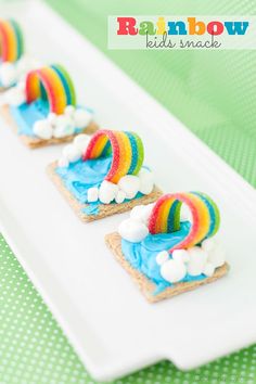 small rainbow sandwiches are on a plate with marshmallows and blue icing