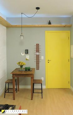 a room with a table and yellow door