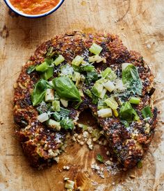 a pizza sitting on top of a wooden cutting board next to a bowl of sauce