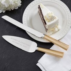 two knives and a piece of cake on a white plate with gold trimmings