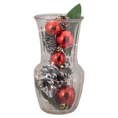 a glass vase filled with ornaments and greenery