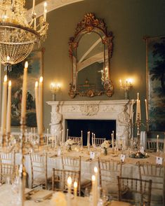 an elegant dining room set up for a formal function with candles and chandeliers