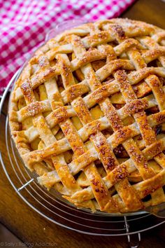 an apple pie with latticed crust sitting on top of a table