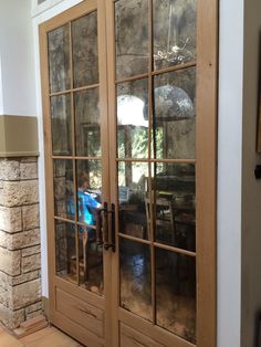 a person sitting at a table with an umbrella in front of two doors that have glass panes on them