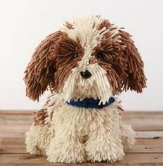 a brown and white dog sitting on top of a wooden floor next to a stuffed animal