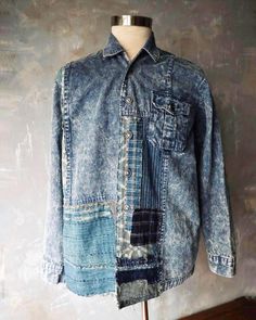 a blue jean jacket with patches on the front and back, sitting on a mannequin's head