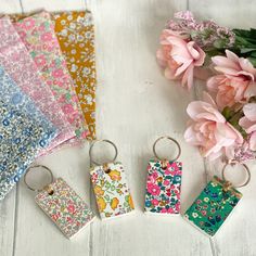 four keychains with flowers on them sitting next to each other