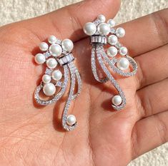 Pearl diamond Earrings featuring semi precious white pearl and cz diamonds. Ideal to pair with your india western sarees and formal outfits. These earrings chendelier design will elevate your look. Perfect gift for her and gift for sister. *𝐏𝐑𝐎𝐃𝐔𝐂𝐓 𝐃𝐄𝐓𝐀𝐈𝐋* * 𝐌𝐚𝐭𝐞𝐫𝐢𝐚𝐥: Brass * 𝐏𝐥𝐚𝐭𝐢𝐧𝐠: White Rhodium Plated * 𝐒𝐭𝐨𝐧𝐞: AAA-quality CZ Diamond. 𝐕𝐢𝐬𝐢𝐭 𝐎𝐮𝐫 𝐅𝐀𝐐𝐬 𝐟𝐨𝐫 𝐒𝐡𝐢𝐩𝐩𝐢𝐧𝐠 𝐏𝐨𝐥𝐢𝐜𝐢𝐞𝐬 𝐚𝐧𝐝 𝐂𝐚𝐫𝐞 𝐈𝐧𝐬𝐭𝐫𝐮𝐜𝐭𝐢𝐨𝐧 *𝐃𝐈𝐒𝐂𝐋𝐀𝐈𝐌𝐄? Luxury Silver Pearl Chandelier Earrings, Luxury Silver American Diamond Chandelier Earrings, Western Sarees, Chandelier Long, Earrings Luxury, Pearl And Diamond Earrings, Designer Replica, Formal Outfits, India Jewelry