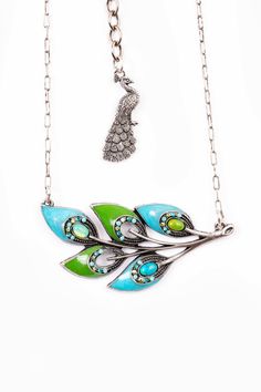 "The ever popular Proud as a Peacock 5 peacock feather pendant set in antique silver with Swarovski crystals in turquoise, blue zircon, and AB peridot with Mohave green turquoise and turquoise semiprecious cabashons, hand enameled in turquoise and green. Approximately measuring 18\" L plus a 3\" extender with a peacock charm." Bohemian Peacock Necklace As Gift, Bohemian Peacock Necklace For Gift, Green Peacock Design Necklace As A Gift, Silver Metal Jewelry With Peacock Design, Green Peacock Design Jewelry Gift, Green Bohemian Jewelry With Charms, Green Oxidized Metal Jewelry, Blue Bohemian Jewelry With Peacock Design, Silver Peacock Pendant Necklace