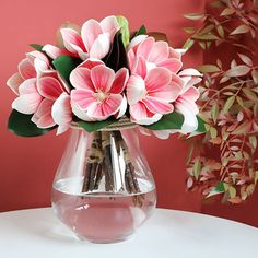 a vase filled with pink flowers on top of a white table