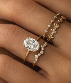 a woman's hand with two rings on it and a diamond ring in the middle