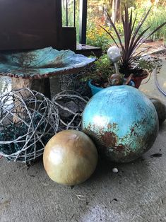 some metal balls and wire sitting on the ground next to each other in front of a house