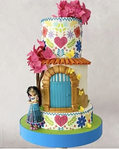 a multi - tiered cake decorated with flowers and a figurine