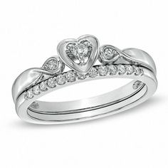 a heart shaped diamond ring set on top of a wedding band with two matching bands