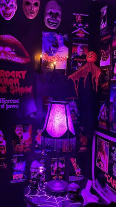 a room filled with halloween decorations and creepy masks on the wall above a table topped with a lamp