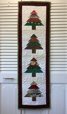 a quilted christmas tree hanging on the wall