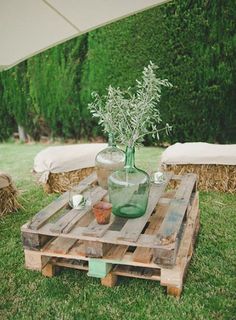 a table made out of wooden pallets in the grass