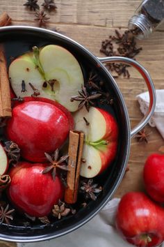 apples, cinnamon and star anise are in a pot on a table with spices