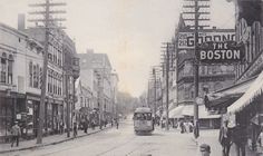 an old black and white photo of people walking down the street