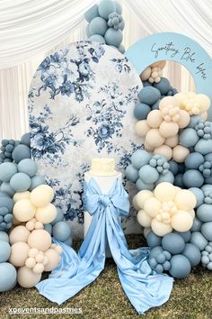 a blue and white cake surrounded by balloons