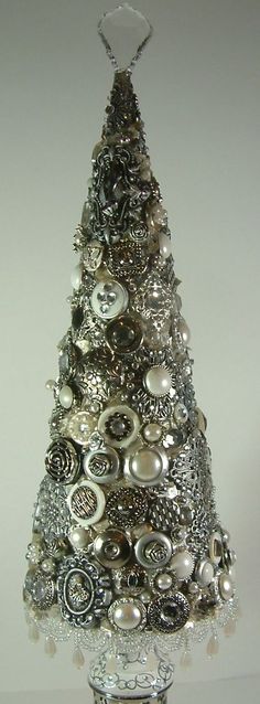 a silver christmas tree made out of buttons