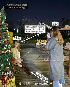 a woman sitting on a deck next to a christmas tree talking on a cell phone