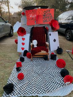 a chair sitting on top of a black and white checkered blanket next to red paper flowers