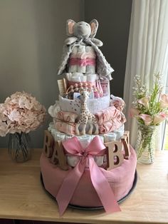 a pink diaper cake sitting on top of a table