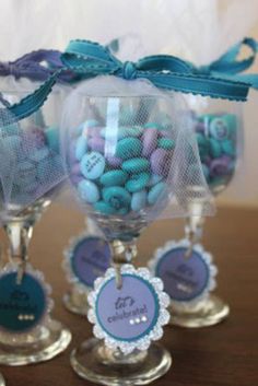 three wine glasses filled with candy on top of a table