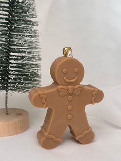 a cookie shaped like a ginger next to a small christmas tree