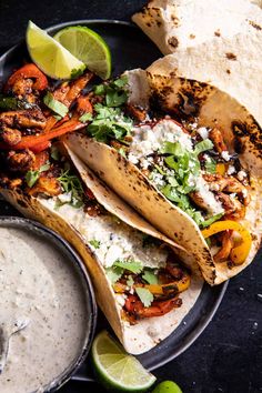 three tacos on a plate with salsa and tortillas