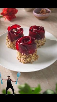 a plate with three desserts on it and a man holding two spoons in front of them