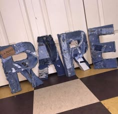 letters made out of jeans sitting on the floor next to each other in front of a door