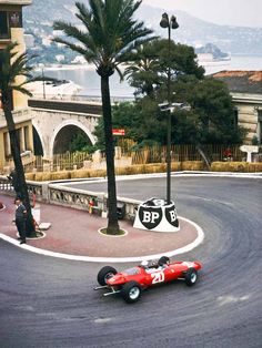 a red race car driving down a winding road