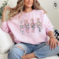 Get cozy this season with our Pink Nutcracker Sweatshirt, featuring a row of 4 unique nutcracker soldiers in beautiful pastel colors. This festive Christmas sweater brings a touch of elegance and charm to your holiday wardrobe, perfect for any winter gathering. Made from soft, high-quality fabric, this Nutcracker ballet sweatshirt offers both warmth and style, making it a must-have for the holiday season. Whether you're looking for a pastel Christmas Outfit to wear to a holiday party or a cute Xmas crewneck for yourself or as a gift, this festive sweatshirt is sure to spread joy and cheer! 💕Proudly printed on Gildan 18000 unisex sweatshirts - Gildan 18000 -50% cotton, 50% polyester - Super soft classic mid-weight fabric 💕Shipping This is a made-to-order item Our turnaround time is 1-3 bu Pink Christmas Sweater, Holiday Movie Night, Pink Nutcracker, Pastel Christmas, Dance Mom, Nutcracker Ballet, Sweatshirt Crewneck, Holiday Wardrobe, Mom Sweatshirt