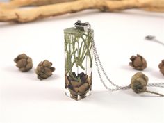 "This elegant handmade crystal clear bar terrarium necklace contains real pinecone and greenery. They have been carefully placed in hand poured resin, done in many steps, to give the necklace a colorful, natural garden appearance. The resin not only protects the delicate flowers, it magnifies their beauty as well. The flowers are floating in a solid block of resin, creating modern, contemporary botanical jewelry The pendant bar measures about 3/8\" square (about 10 mm) and 1 3/8\"(35mm) long; an Gardening For Dummies, Small Pine Cones, Pinecone Necklace, Terrarium Necklace, Botanical Jewelry, Delicate Flowers, Natural Garden, Real Plants, Resin Necklace