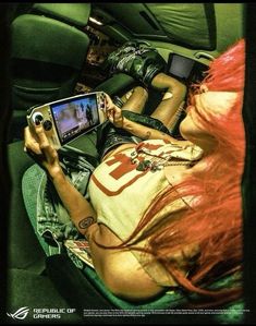 a woman laying in the back seat of a car holding a game controller