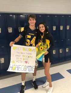 two people standing in front of lockers holding flowers and a sign that says welcome to me coming