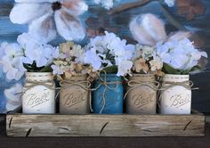 three mason jars with white flowers in them