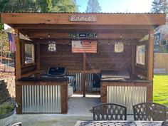 an outdoor bbq with grills, tables and chairs