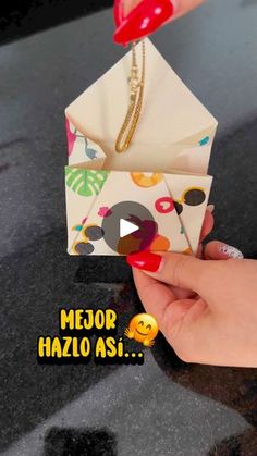 a woman's hand holding an origami envelope with a smile on it