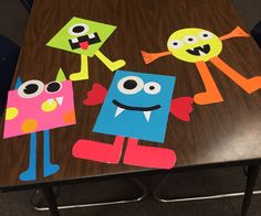 three paper monsters on a wooden table