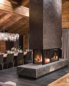 a dining room with a fireplace and chandelier hanging from the ceiling