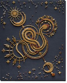 an intricately designed piece of art made from beads and other materials on a black surface