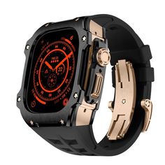 the watch is black and gold with an orange light on it's display case