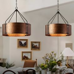 two chandeliers hanging from the ceiling in a living room