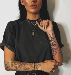 a woman with tattoos on her arms posing for the camera