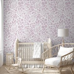 a baby's room with a crib, rocking chair and flower wallpaper